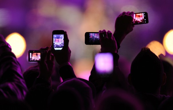 Fans take photos with their mobile phones during the VH1 Divas Salute The Troops show in San Diego