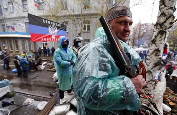 A pro-Russian armed man stands guard at a barricade near the police headquarters in Slaviansk