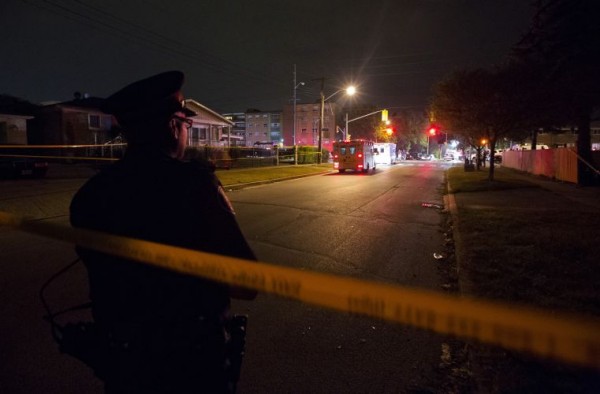 A police officer watches over a crime scene following a shooting in Scarborough, a suburb in east Toronto